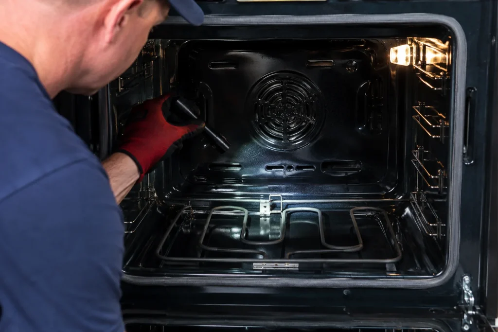 technician inspecting oven heating element during diagnosis